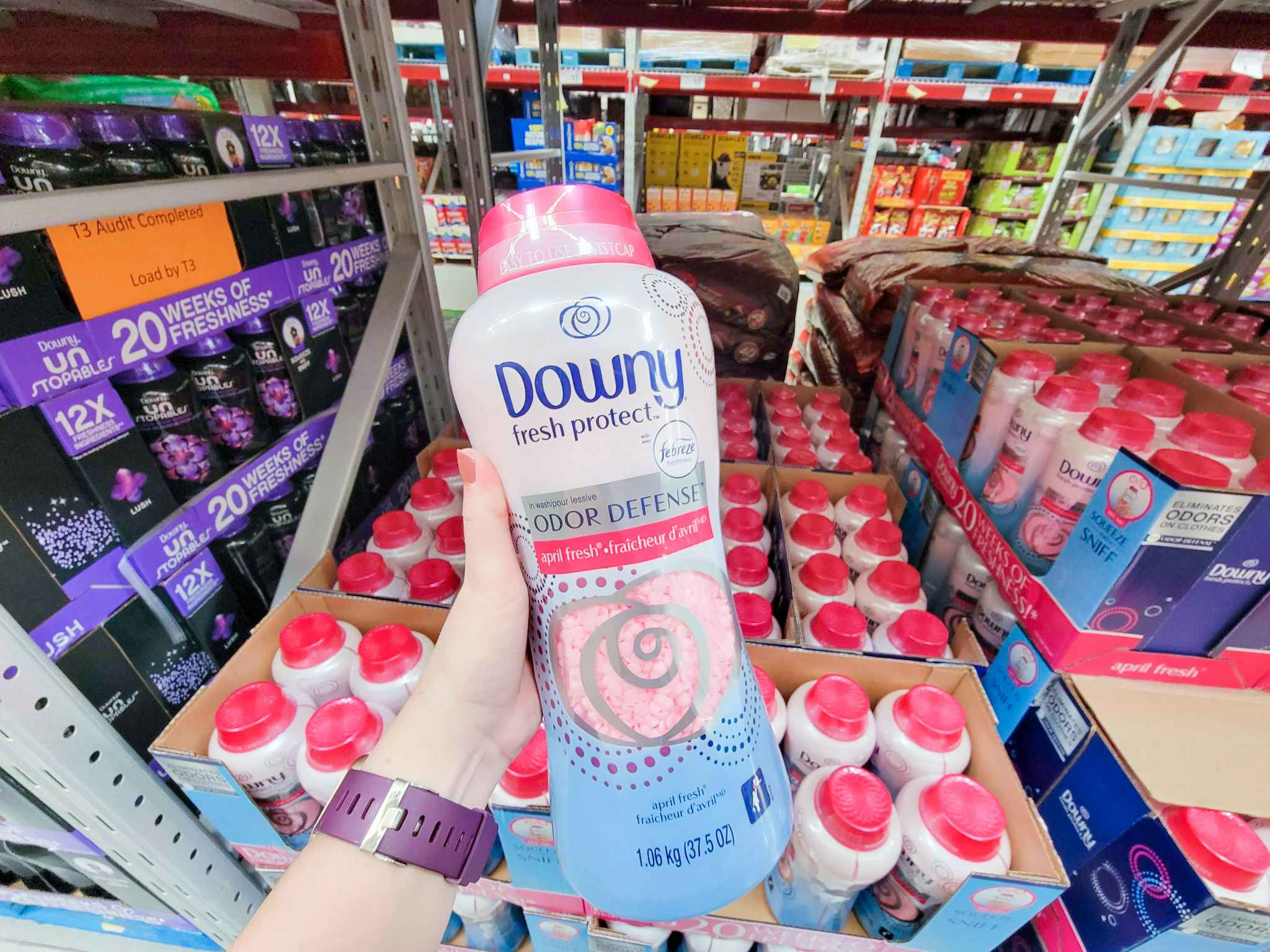 hand holding a large bottle of downy scent booster