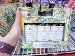 hand holding a 3-pack of glass bottles of hand soap on a shelf