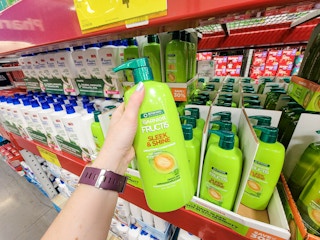 hand holding a large bottle of garnier fructis sleek and shine conditioner