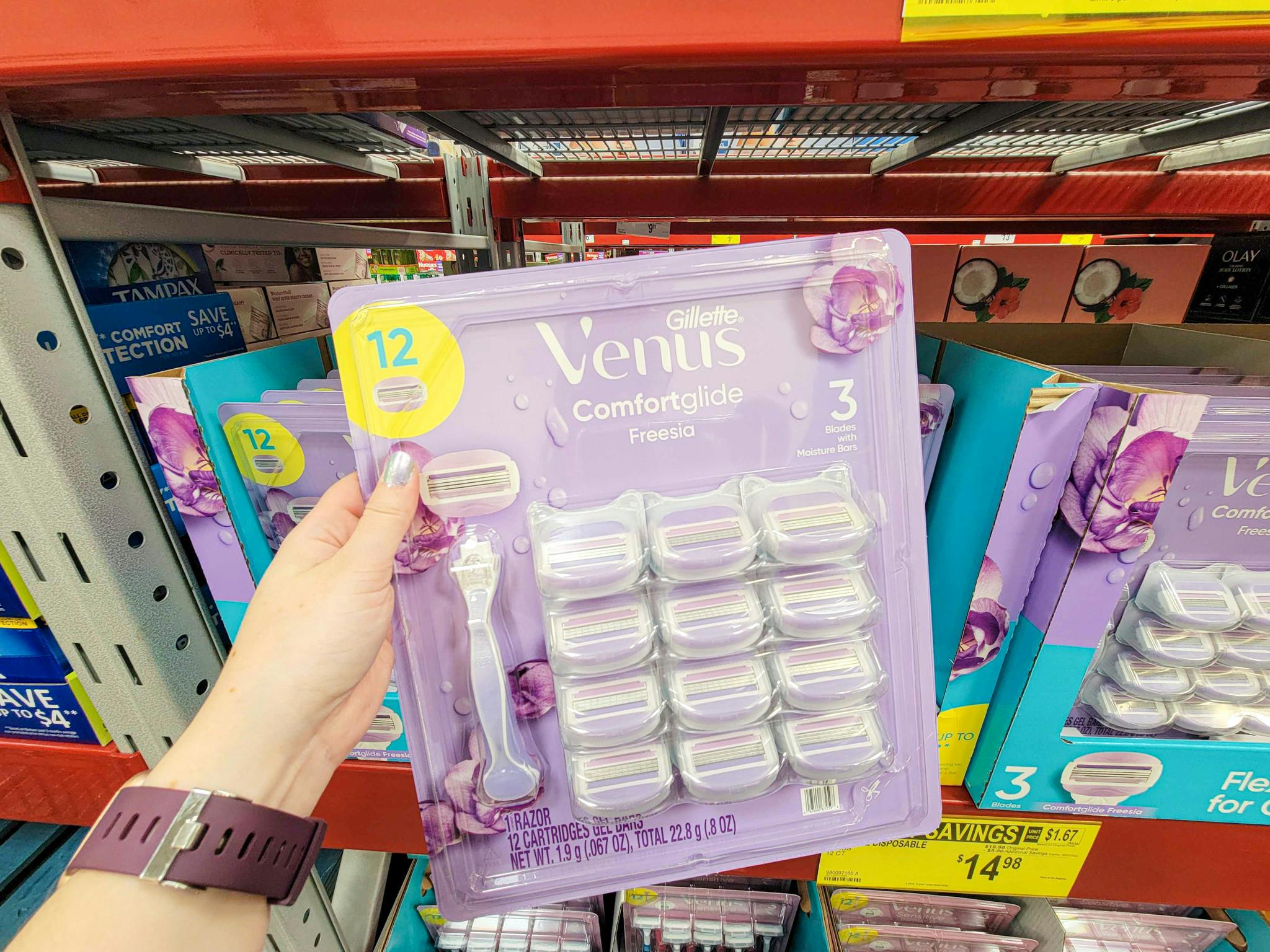 hand holding a pack of gillette venus comfort glide freesia razors 12 pack with a handle