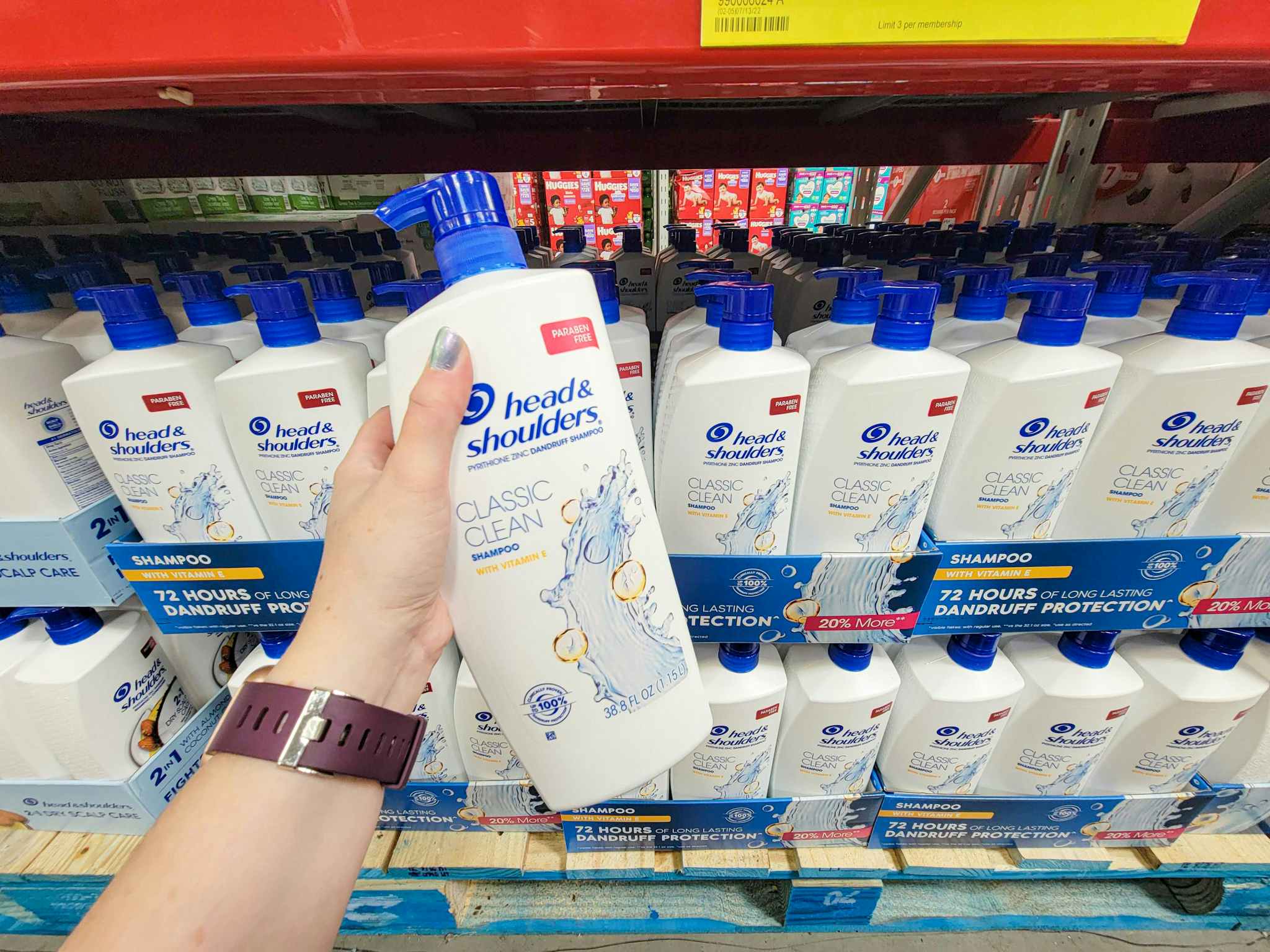 hand holding a large bottle of head and shoulders shampoo