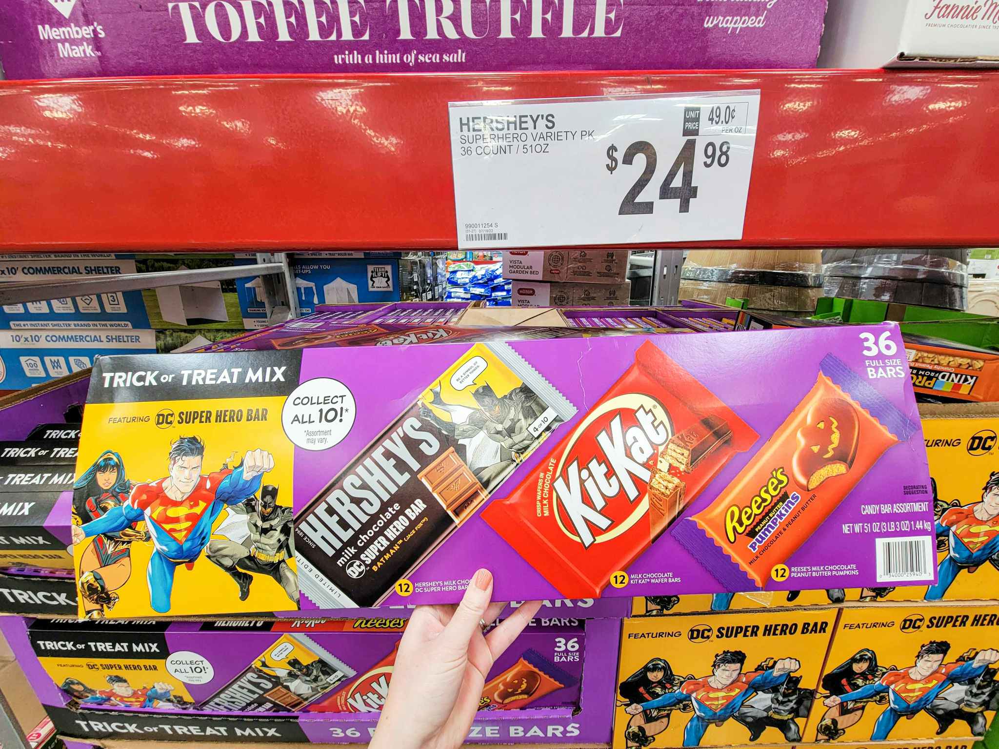 hand holding a box of full size hersheys, reeses, and kit kat bars for halloween