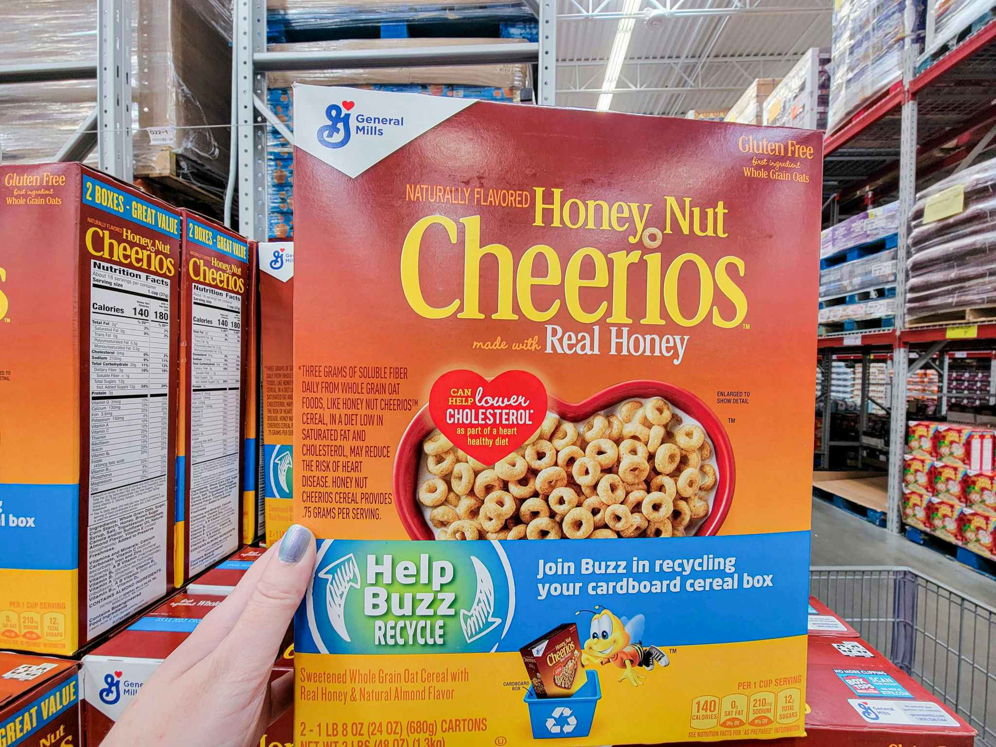 hand holding a 2-pack of honey nut cheerios boxes