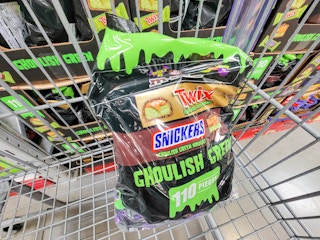 a large bag of twix, snickers, and m&ms candy in a cart for halloween