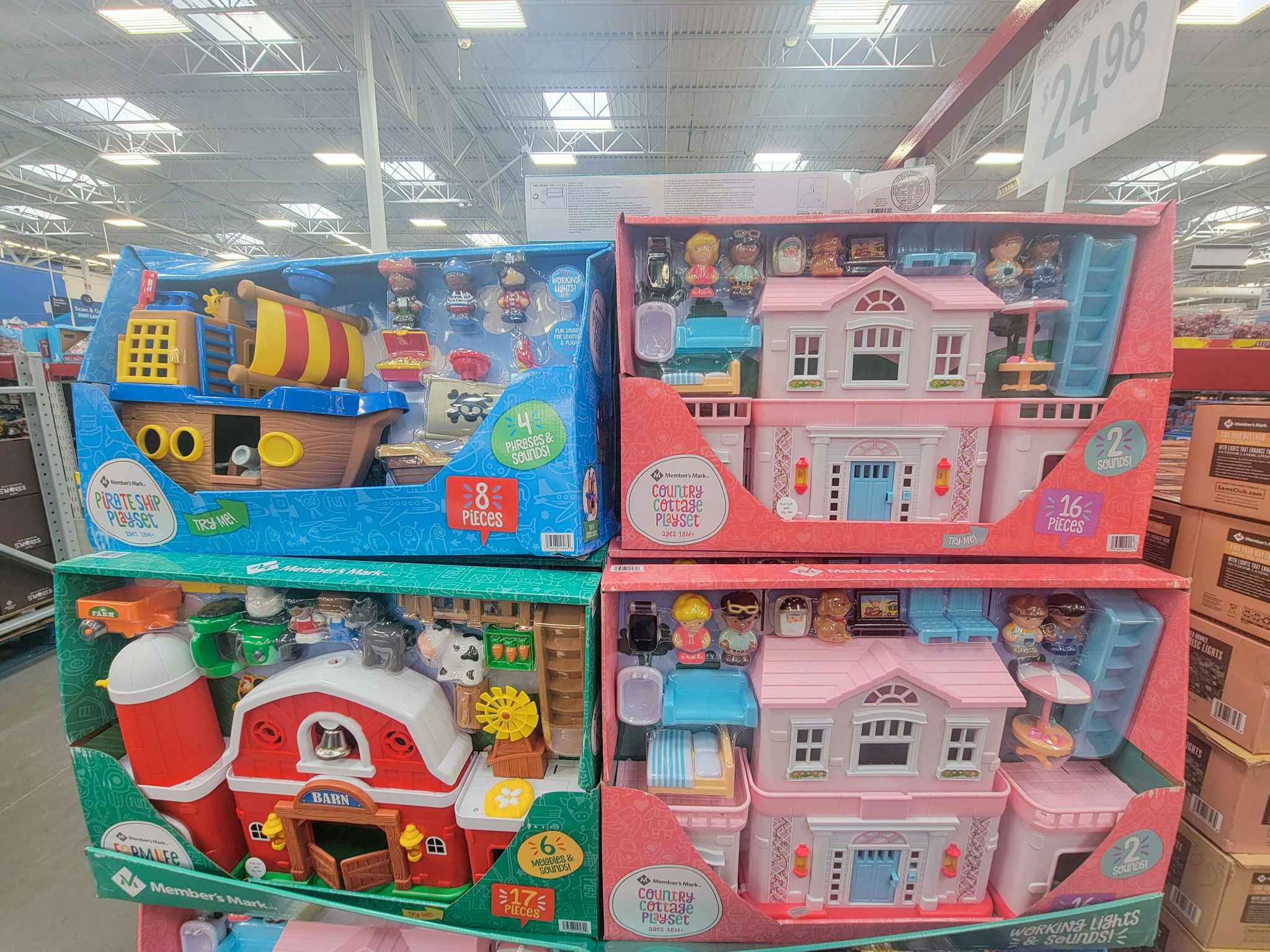 display of kids playsets, including a pirate ship, pink cottage, and a barn