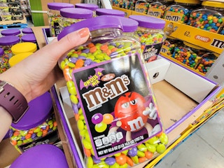 hand holding a container of halloween m&ms ghoul themed colors