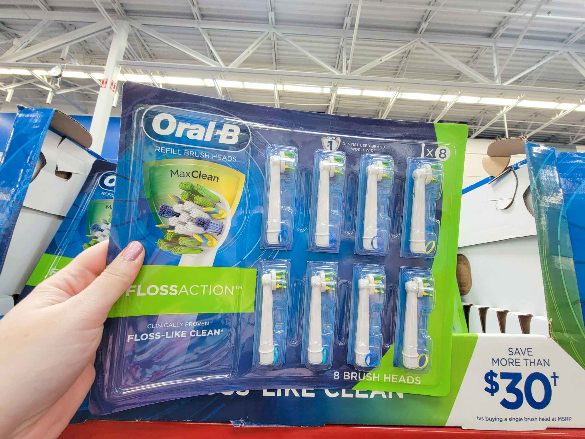 hand holding an 8 pack of replacement heads for oral b electric toothbrushes