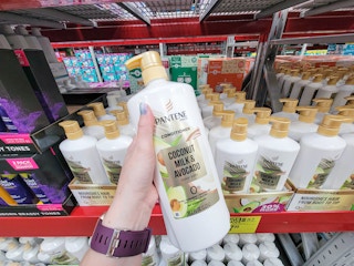 hand holding a large bottle of pantene coconut milk and avocado conditioner