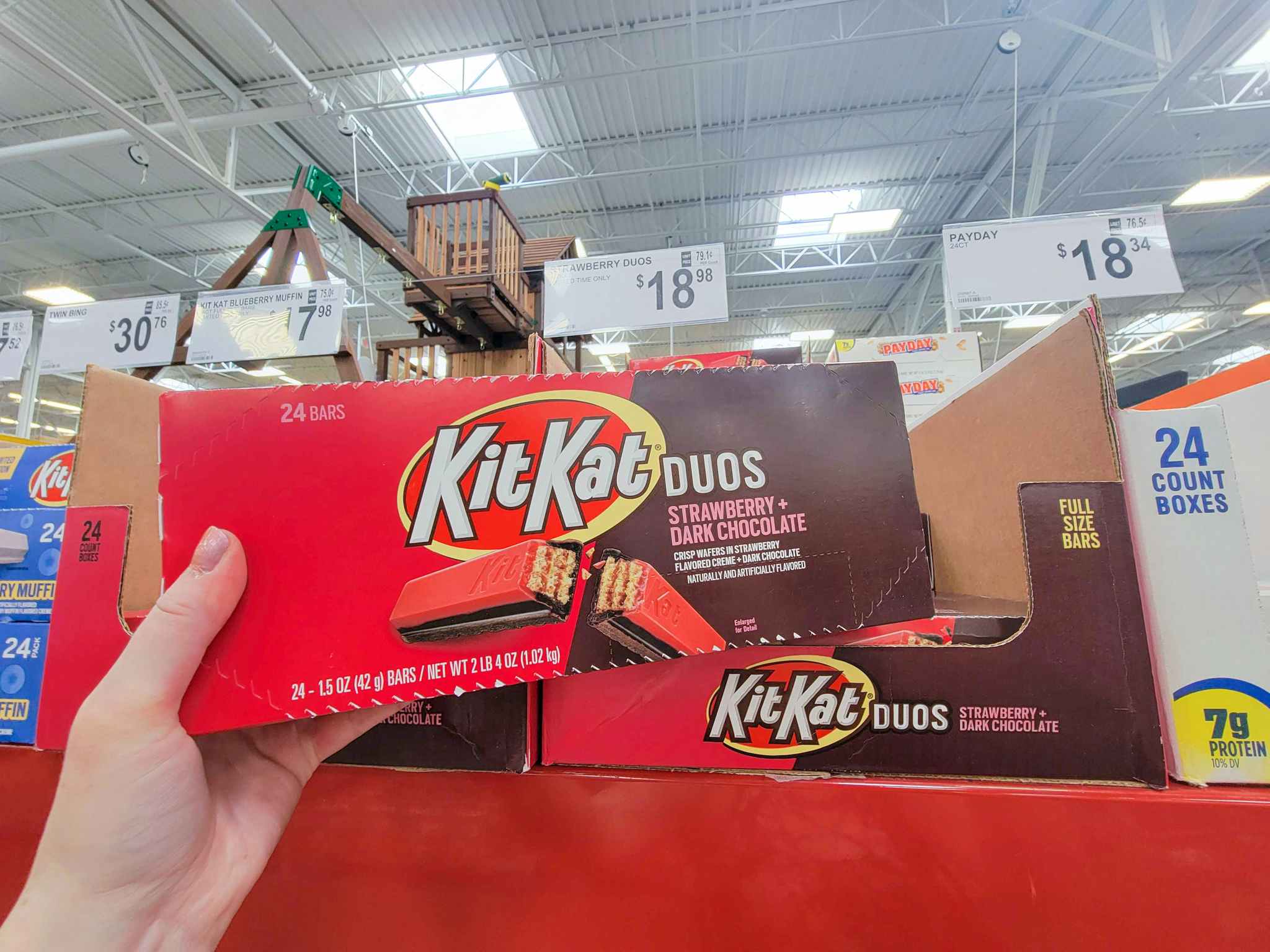hand holding a box of strawberry chocolate kit kats
