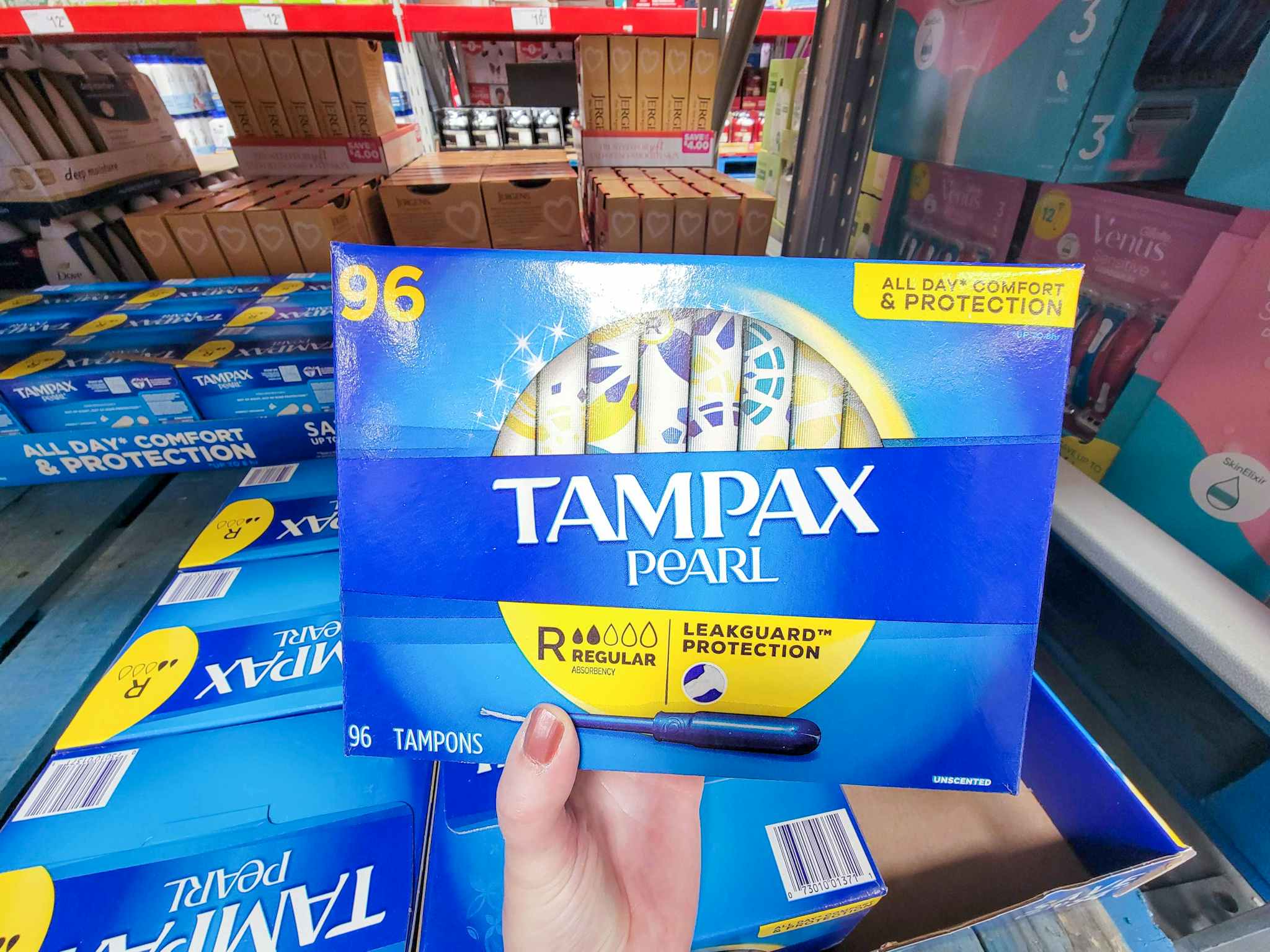 hand holding a 96 ct box of tampax pearl regular absorbency tampons