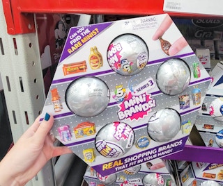 hand holding a 5-pack of zuru surprise mini brand toys