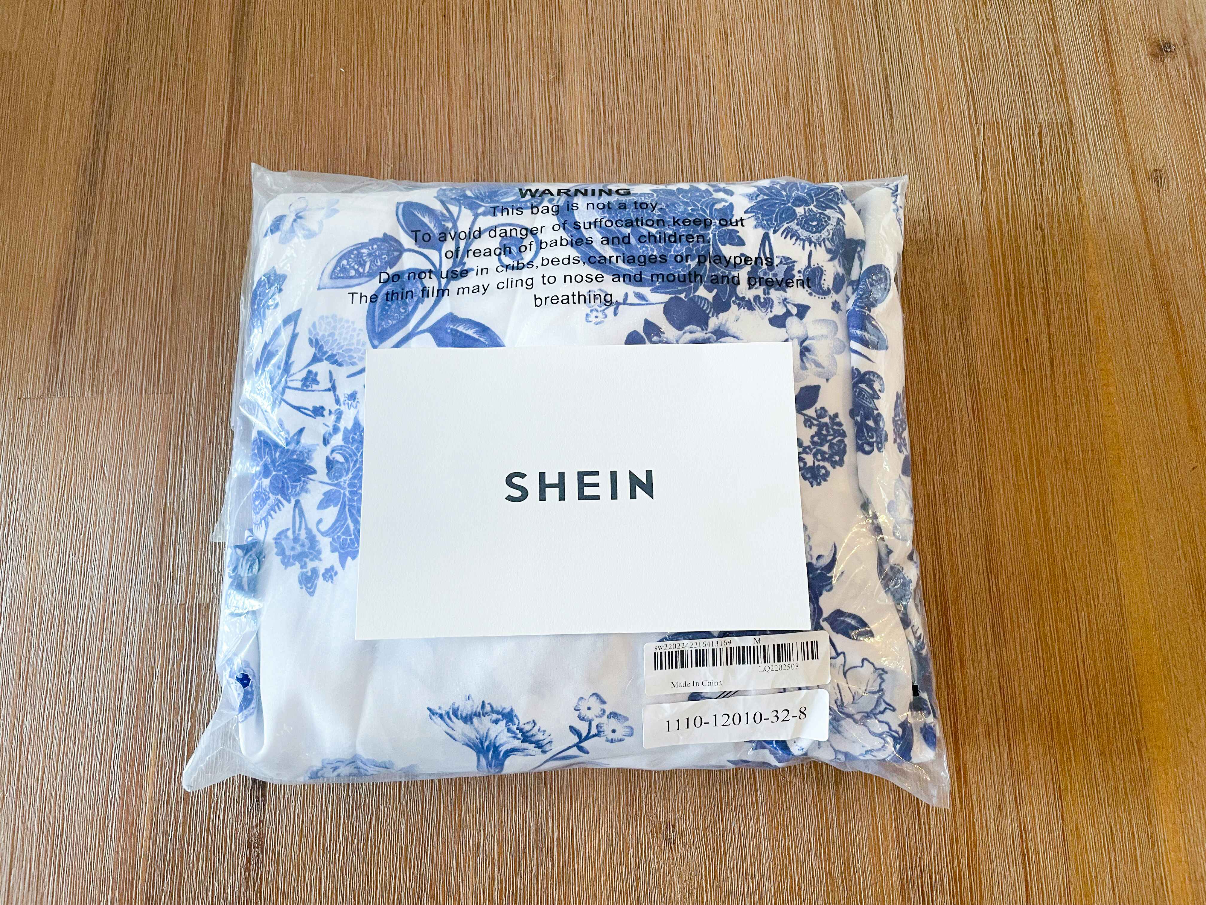 a blue and white dress from SheIn packaged in a bag with the SheIn logo on top of it