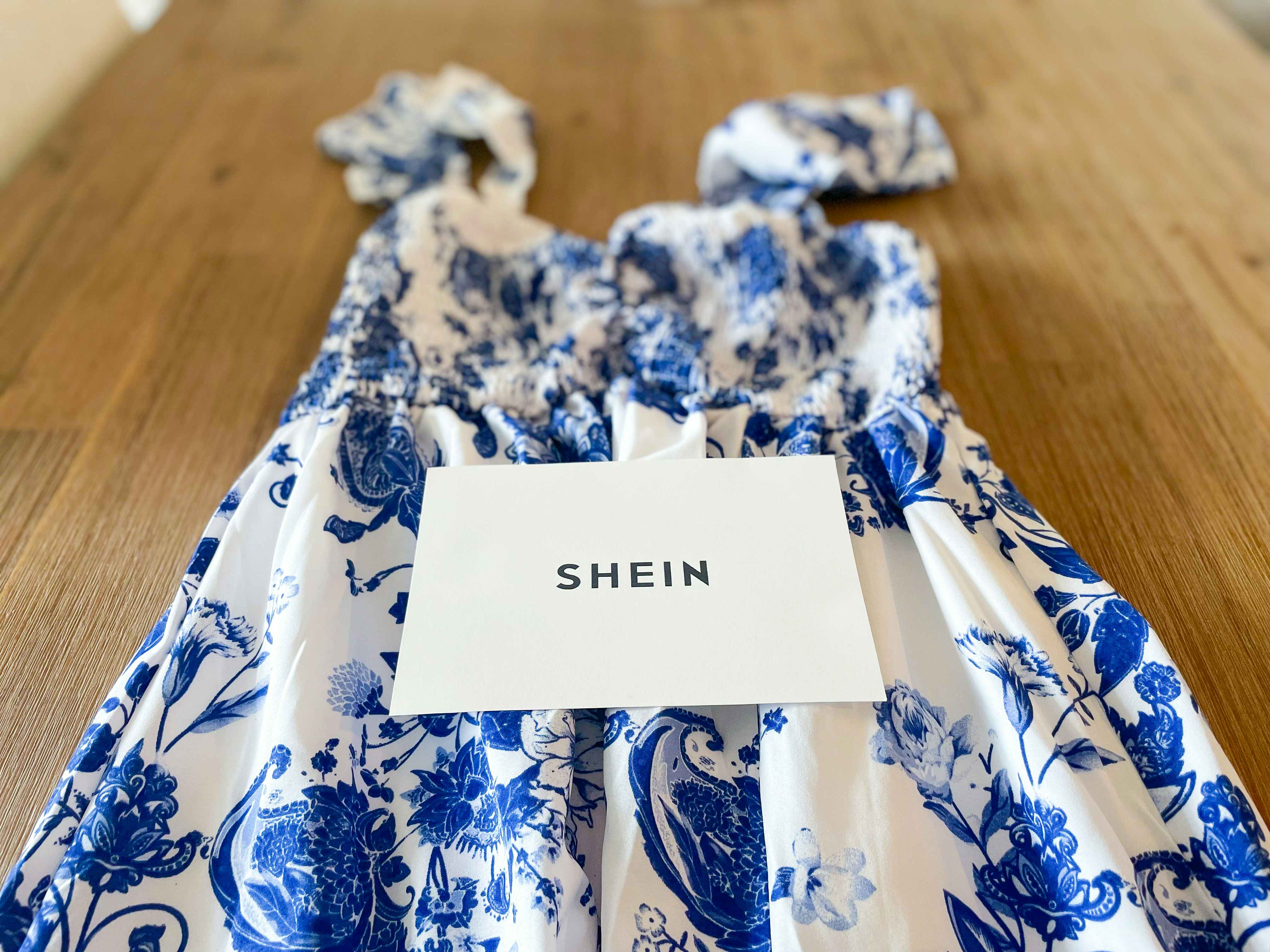 a blue and white maxi dress from Shein laid across a table with a SheIn card on top of it