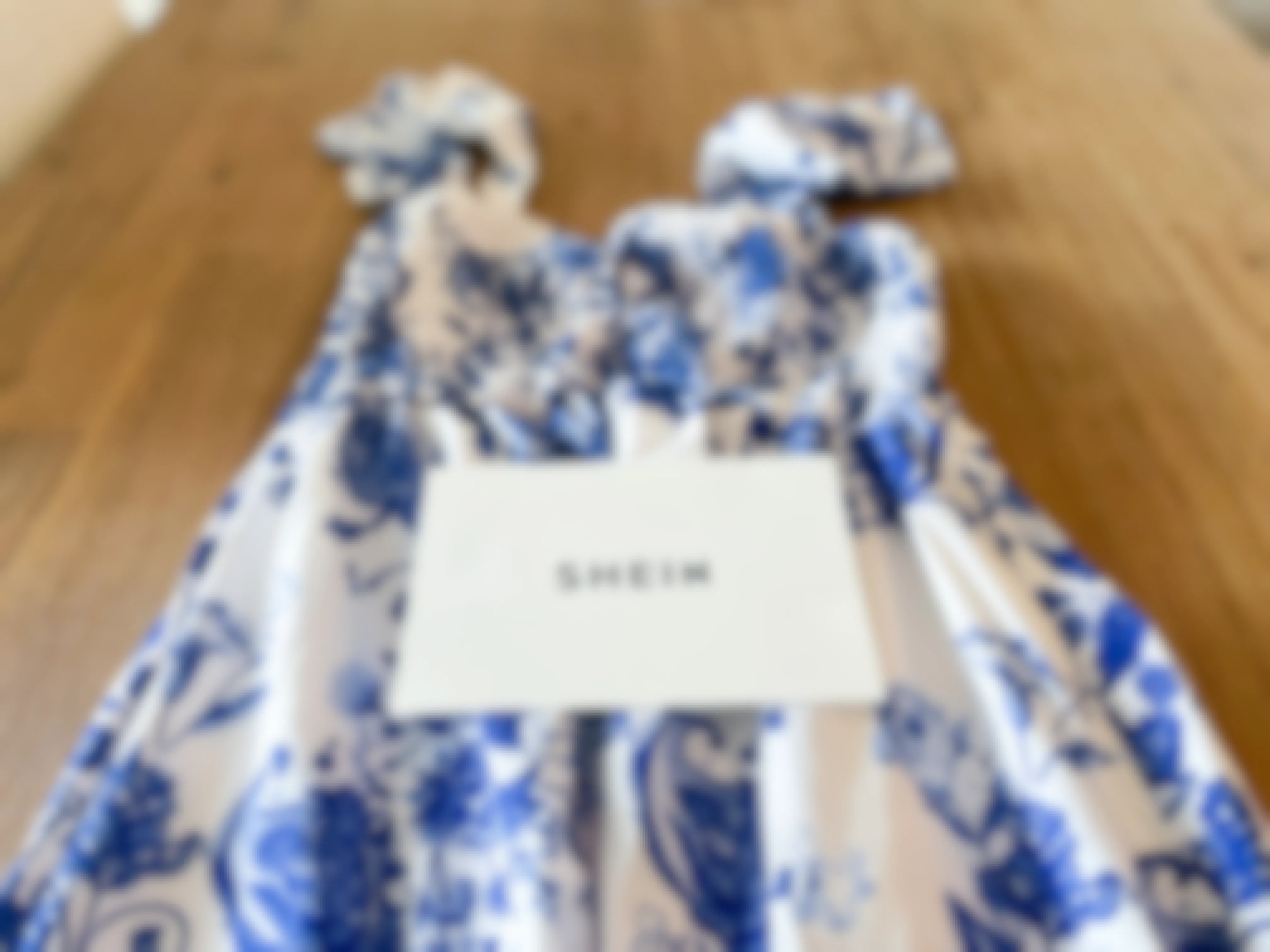 a blue and white maxi dress from Shein laid across a table with a SheIn card on top of it