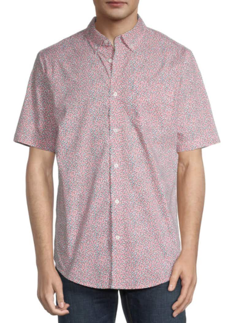 a pink short sleeve button down shirt with flowers all over