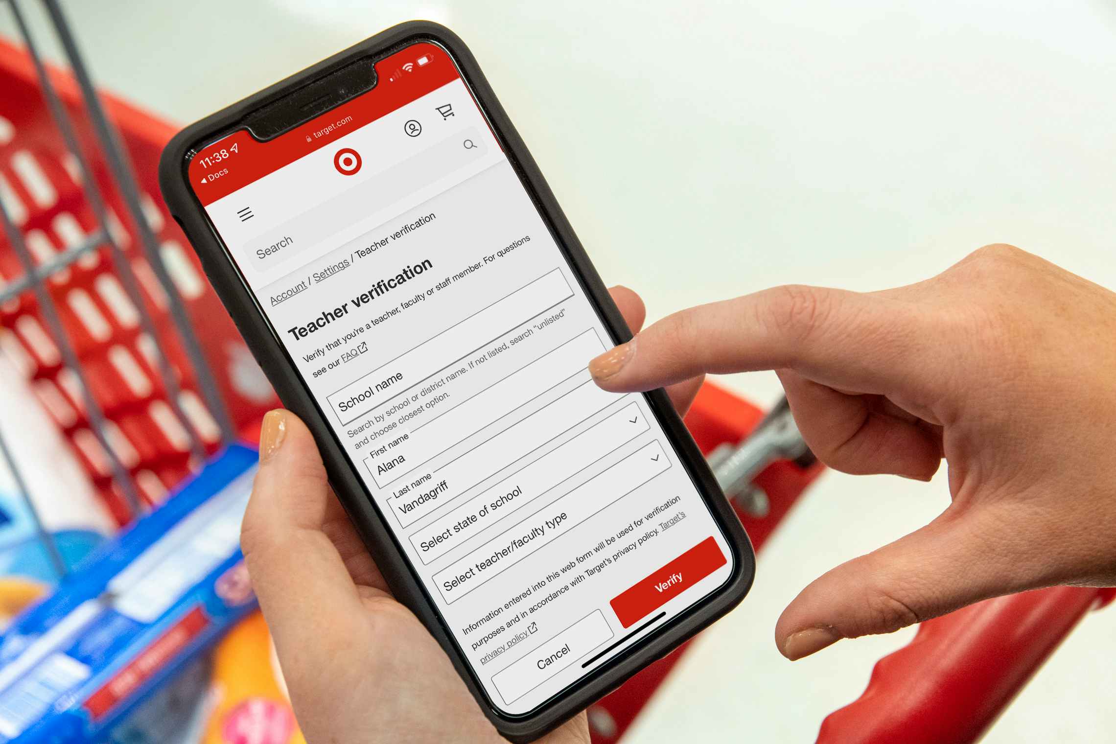 A person holding their iPhone, filling out the Teacher Verification form on the Target circle app.