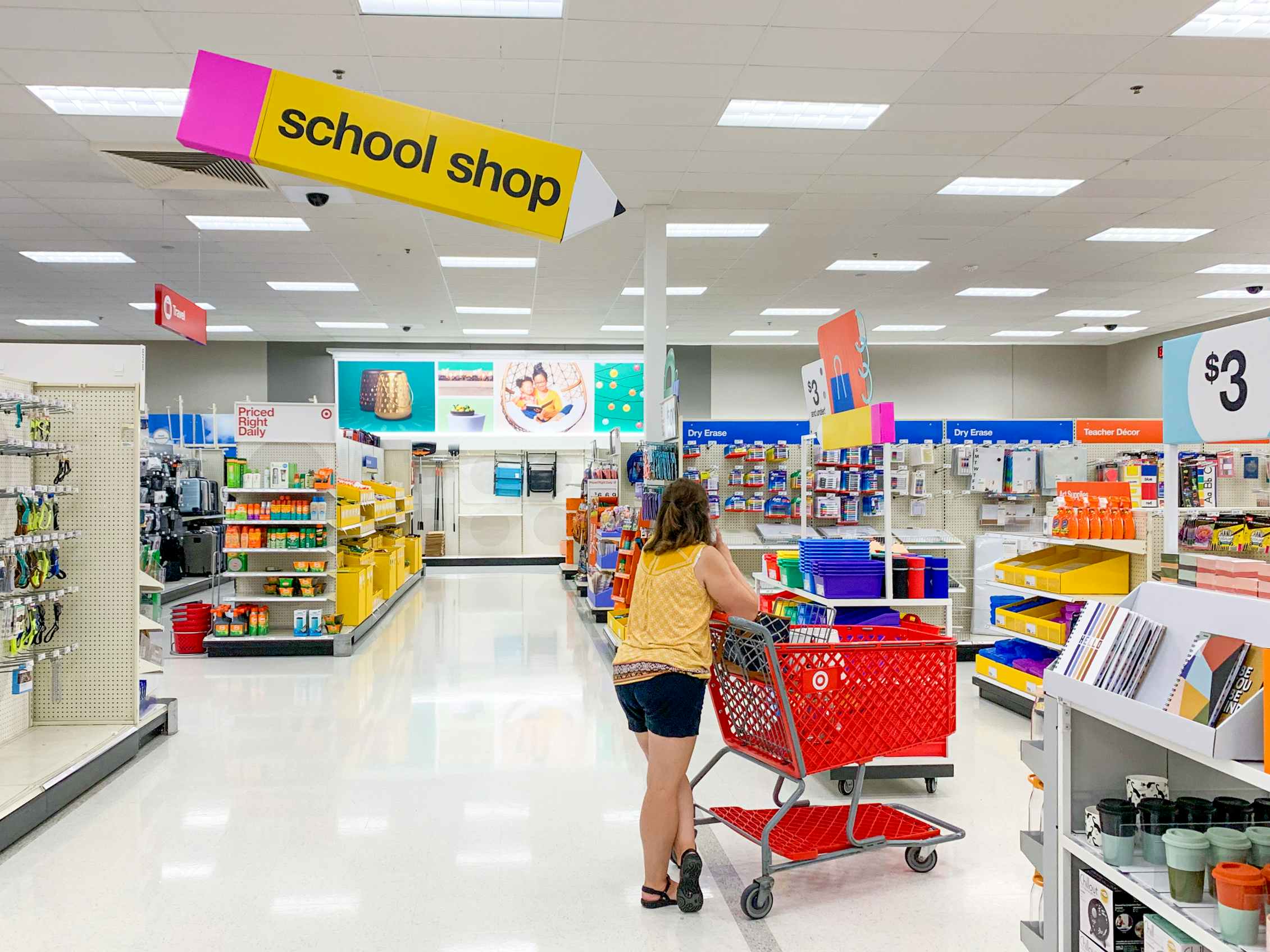 A woman standing behind a cart in the school supply section at Target