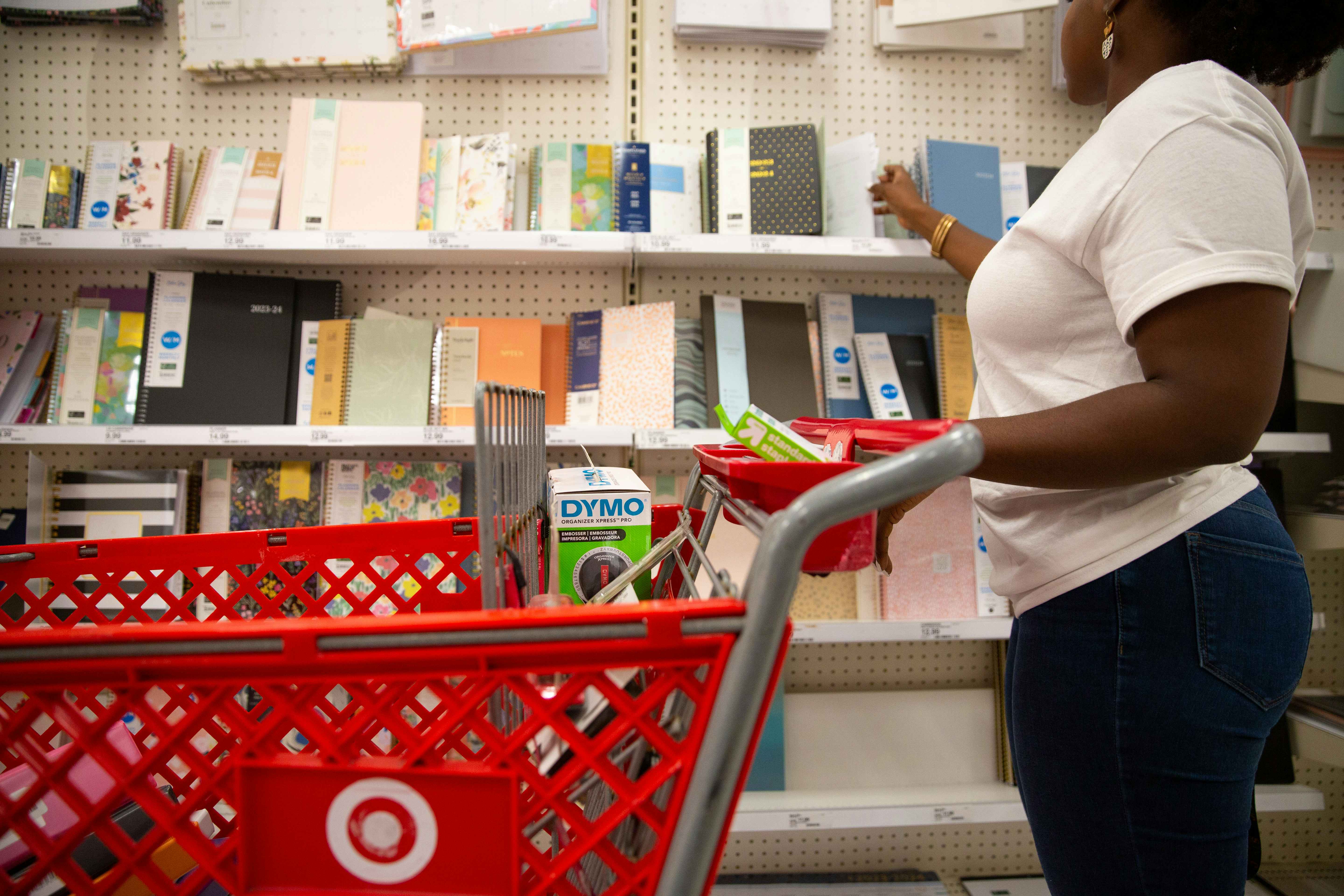 Person in white shirt looking at a row of notebooks for sale at target