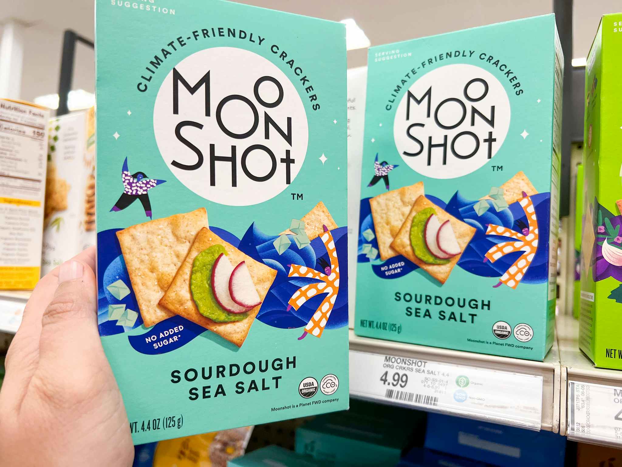 A person taking a box of moonshot crackers off a target shelf