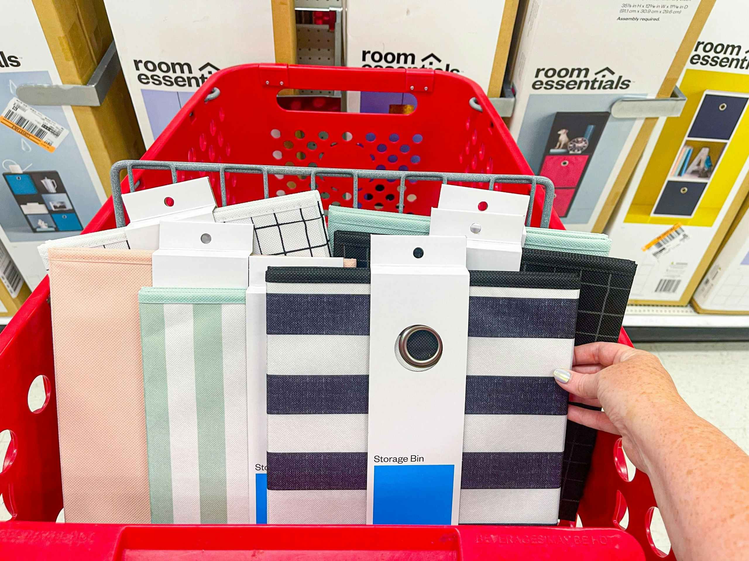 hand holding room essentials cube storage bin in target cart