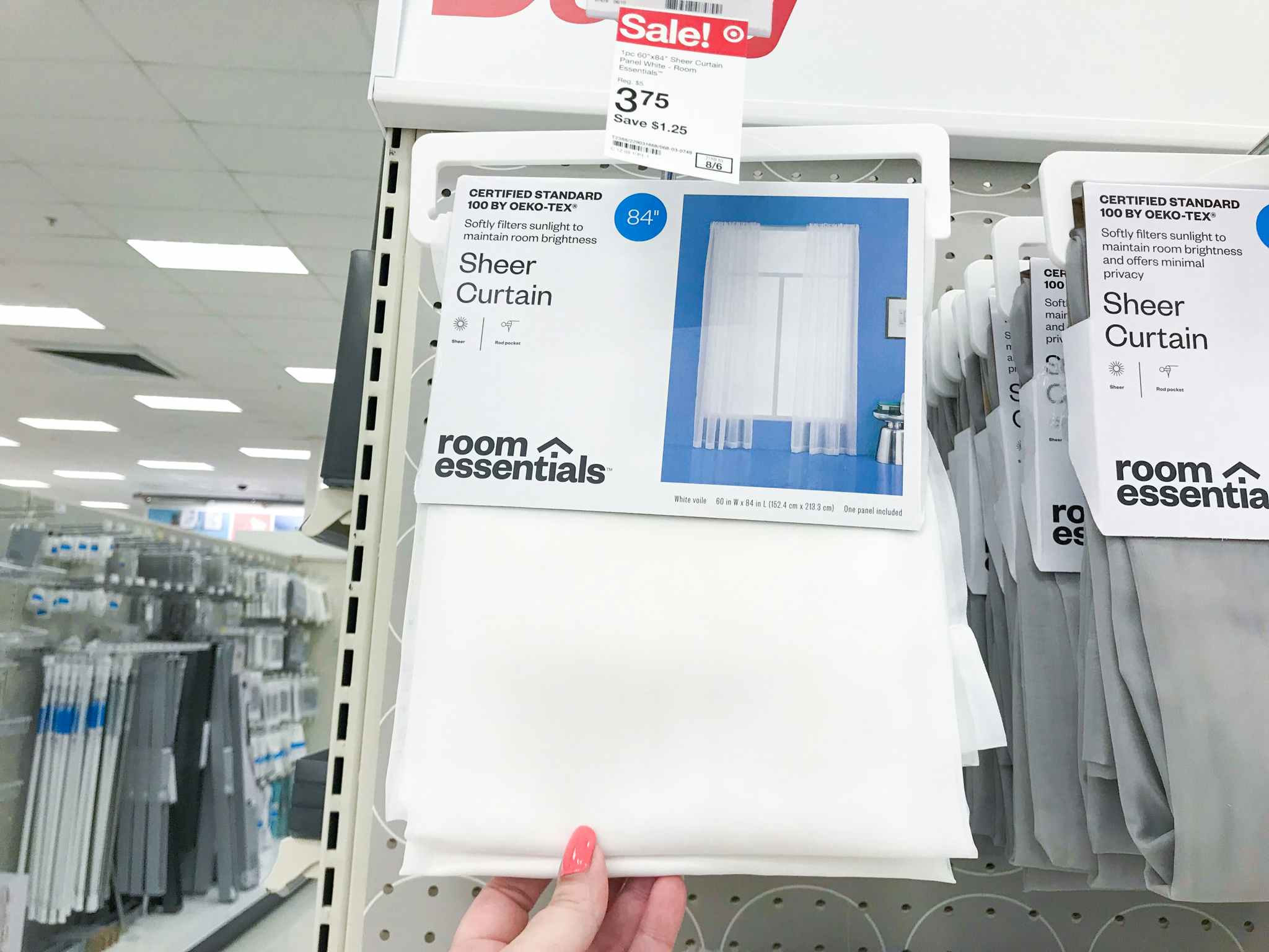 hand holding white room essentials sheer curtain at target