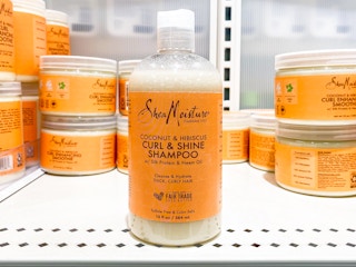 A bottle of SheaMoisture Curl and Shine Coconut Shampoo on a shelf at Target.