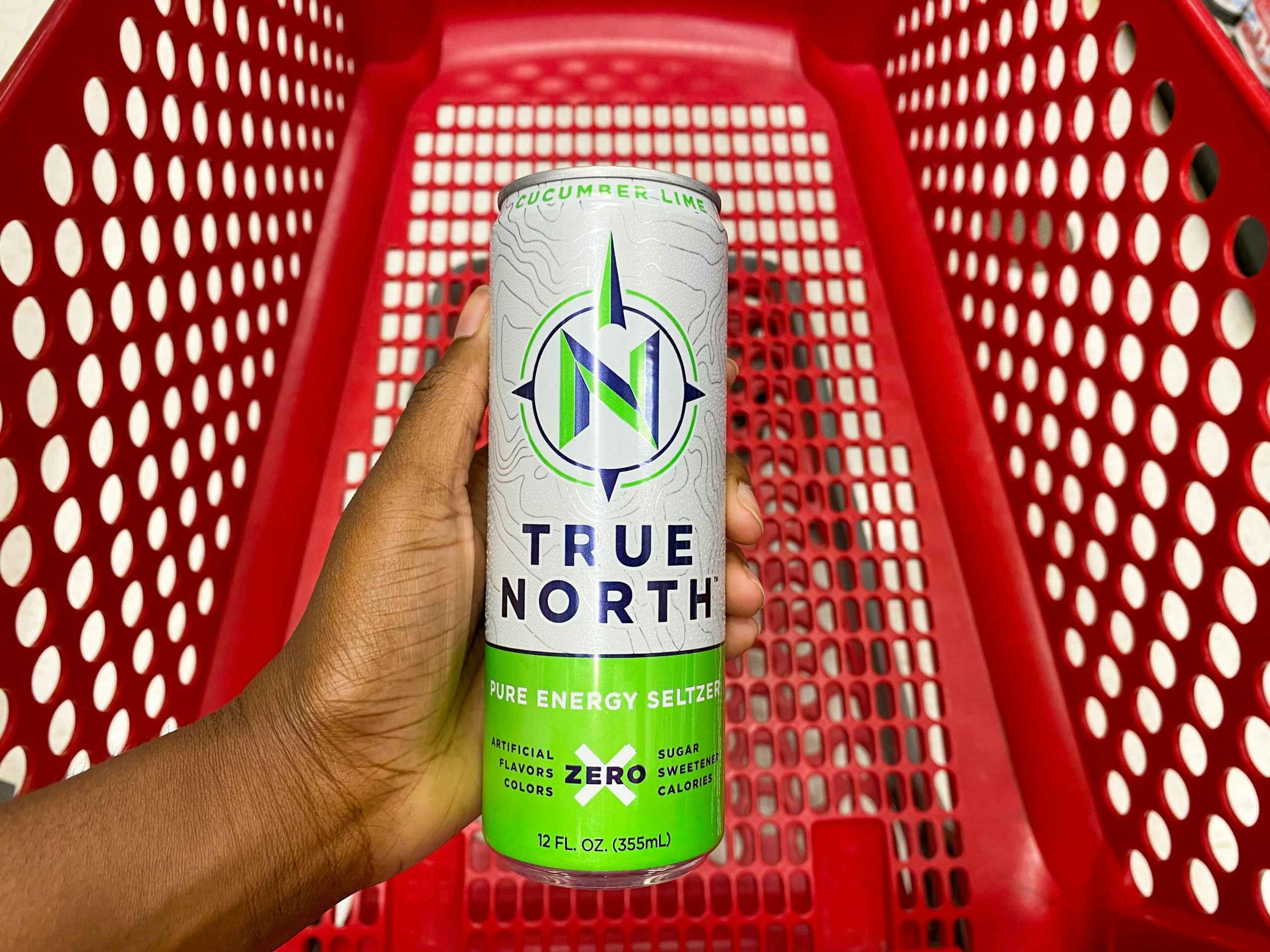 hand holding up a can of True North seltzer over the top of a Target cart