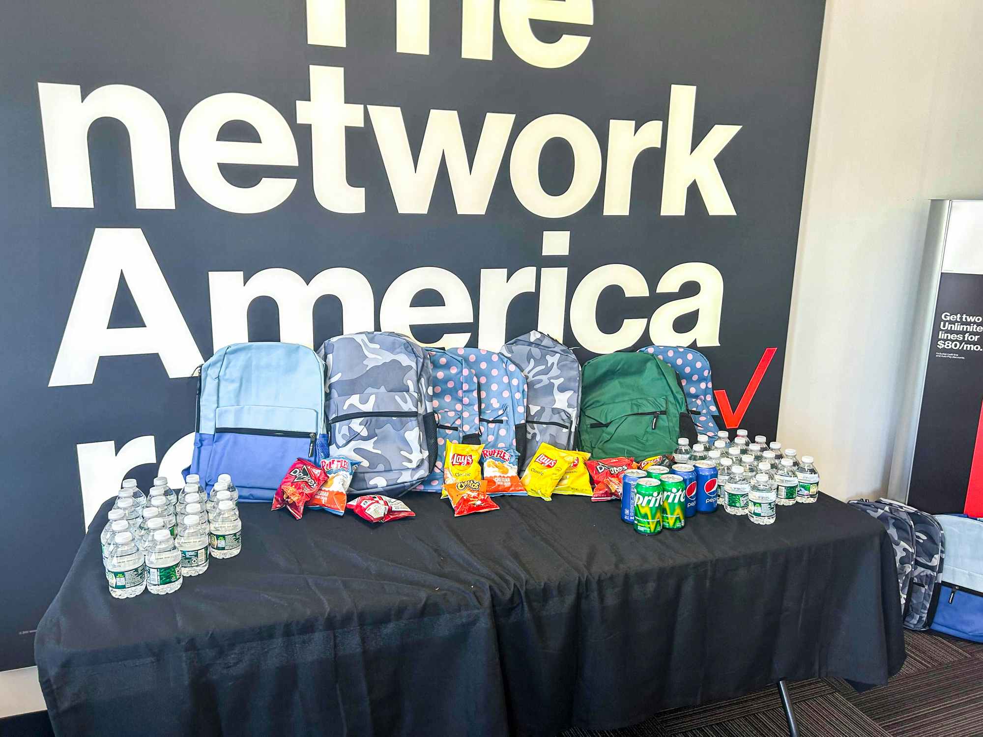 verizon backpacks lined up on a table inside of a verizon store