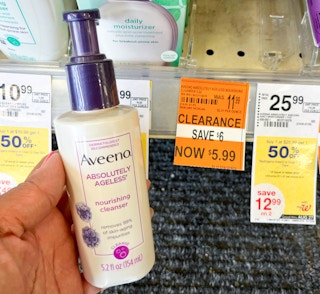hand holding bottle of Aveeno Absolutely Ageless cleanser next to clearance tag