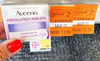 hand holding box of Aveeno Absolutely Ageless Restorative Night cream next to clearance tag