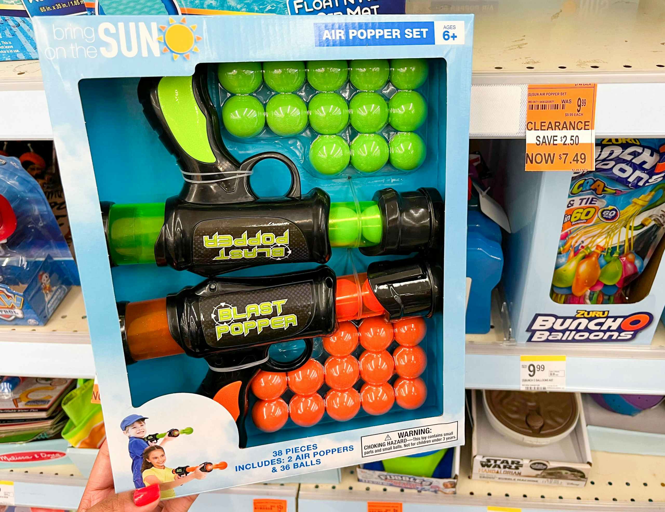 hand holding box of a set of air poppers next to clearance tag