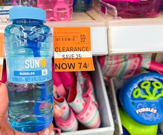 hand holding bottle of bubbles next to clearance tag