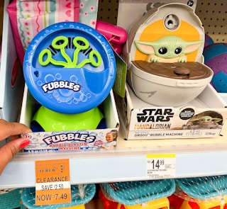 hand touching Fubbles bubble machine on shelf with clearance tag underneath