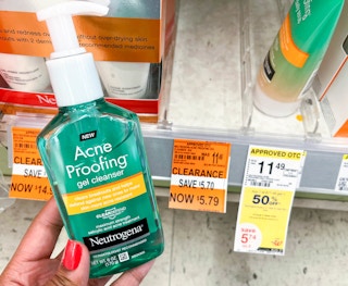 hand holding bottle of Neutrogena acne proofing gel cleanser next to clearance tag