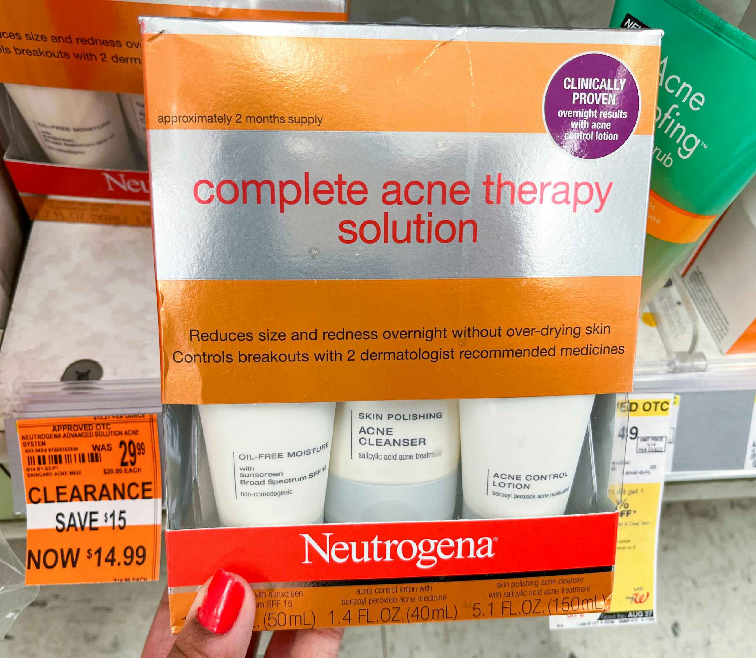 hand holding up a box Neutrogena complete acne therapy solution with clearance tag to the left of it