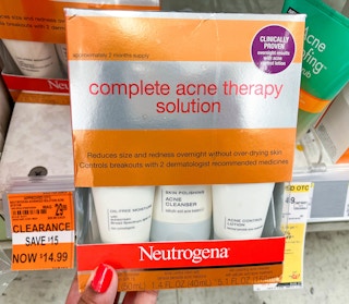 hand holding up a box Neutrogena complete acne therapy solution with clearance tag to the left of it
