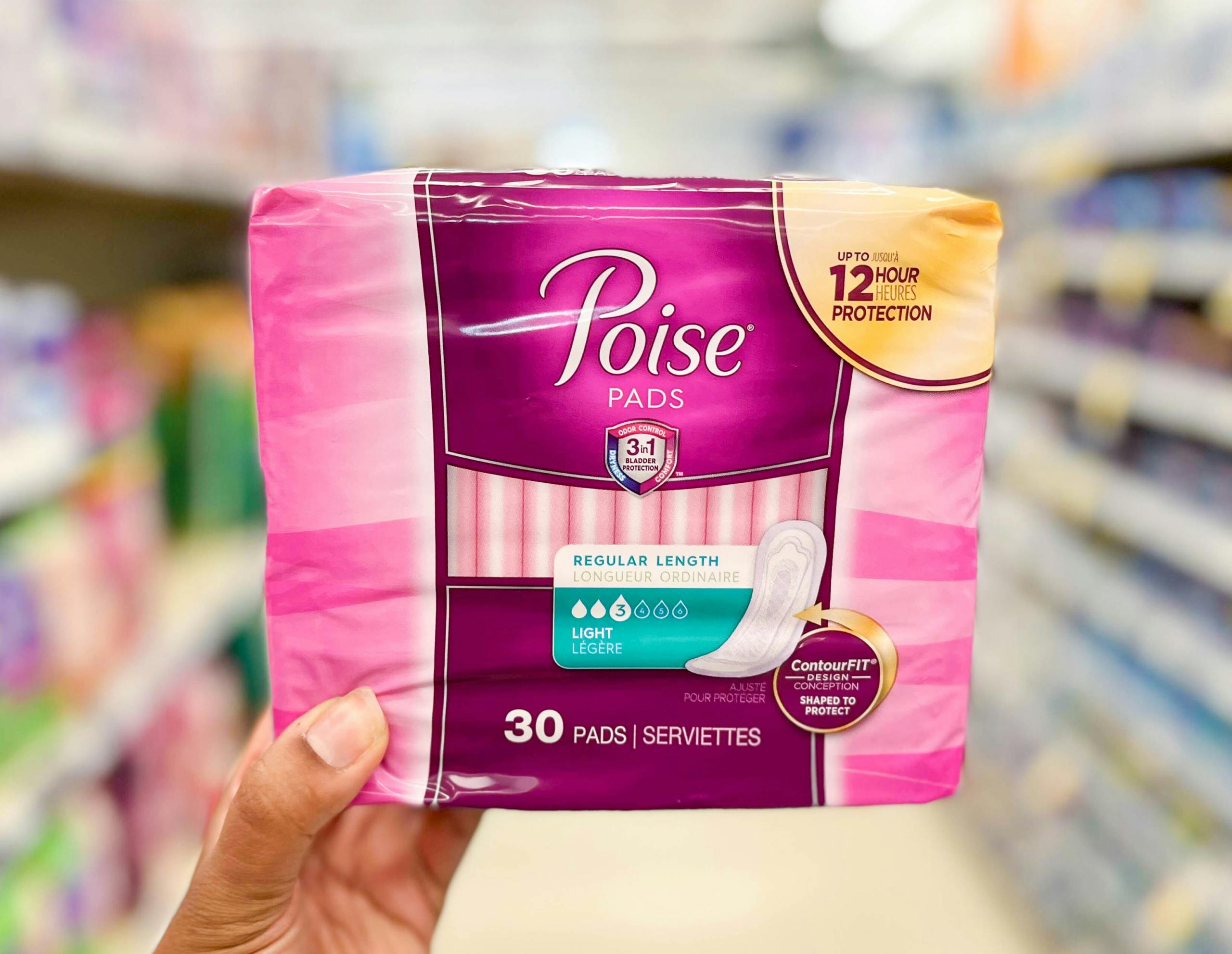 hand holding pack of Poise pads
