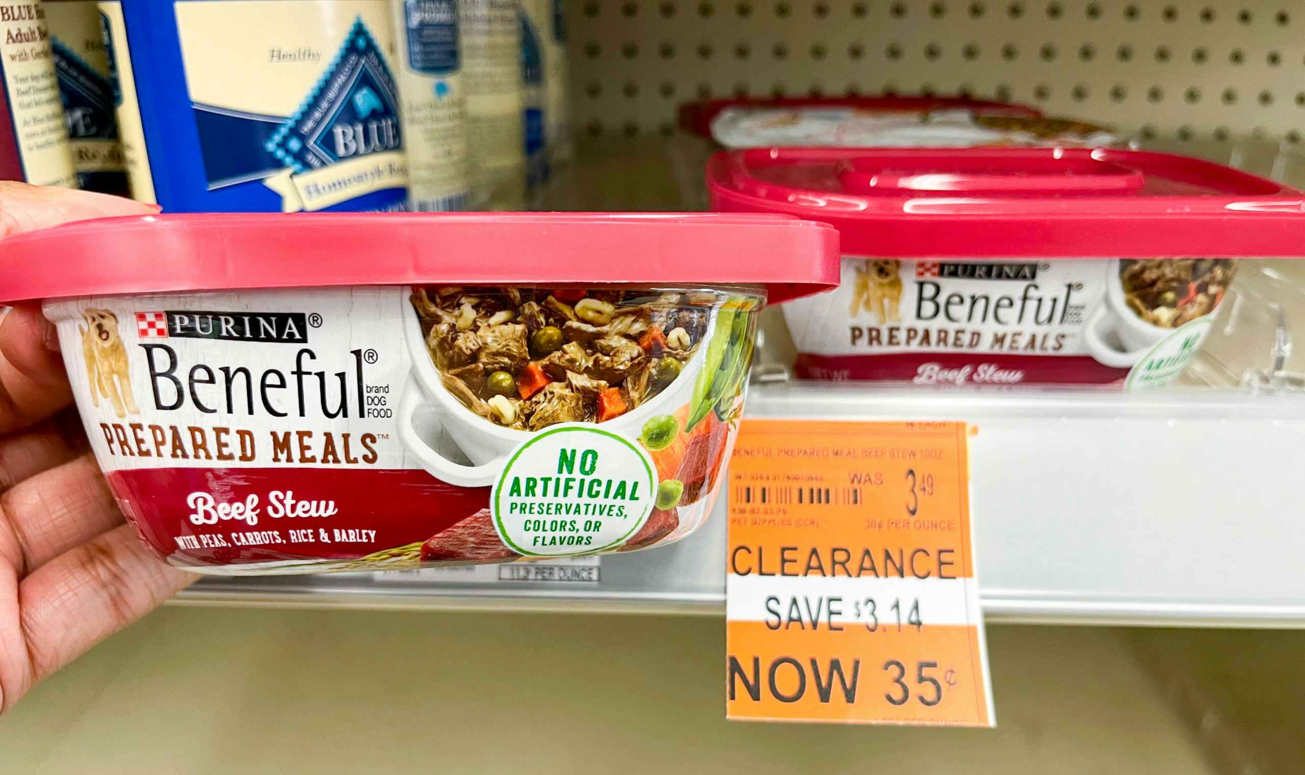 hand holding a container of Purina Beneful Prepared Meals next to clearance tag