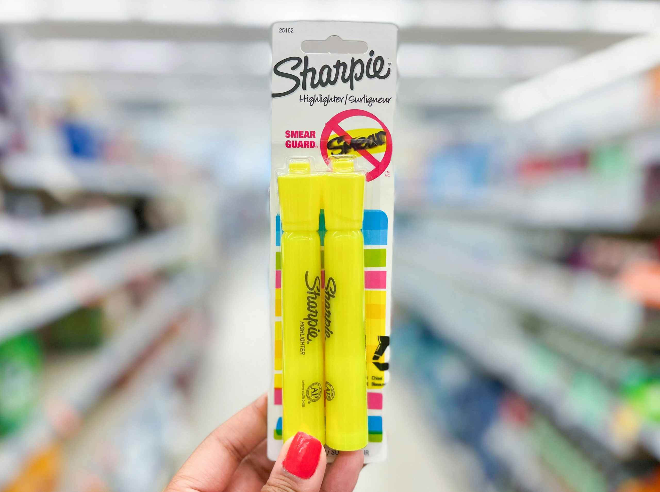 Hand holding pack of Sharpie highlighters in aisle
