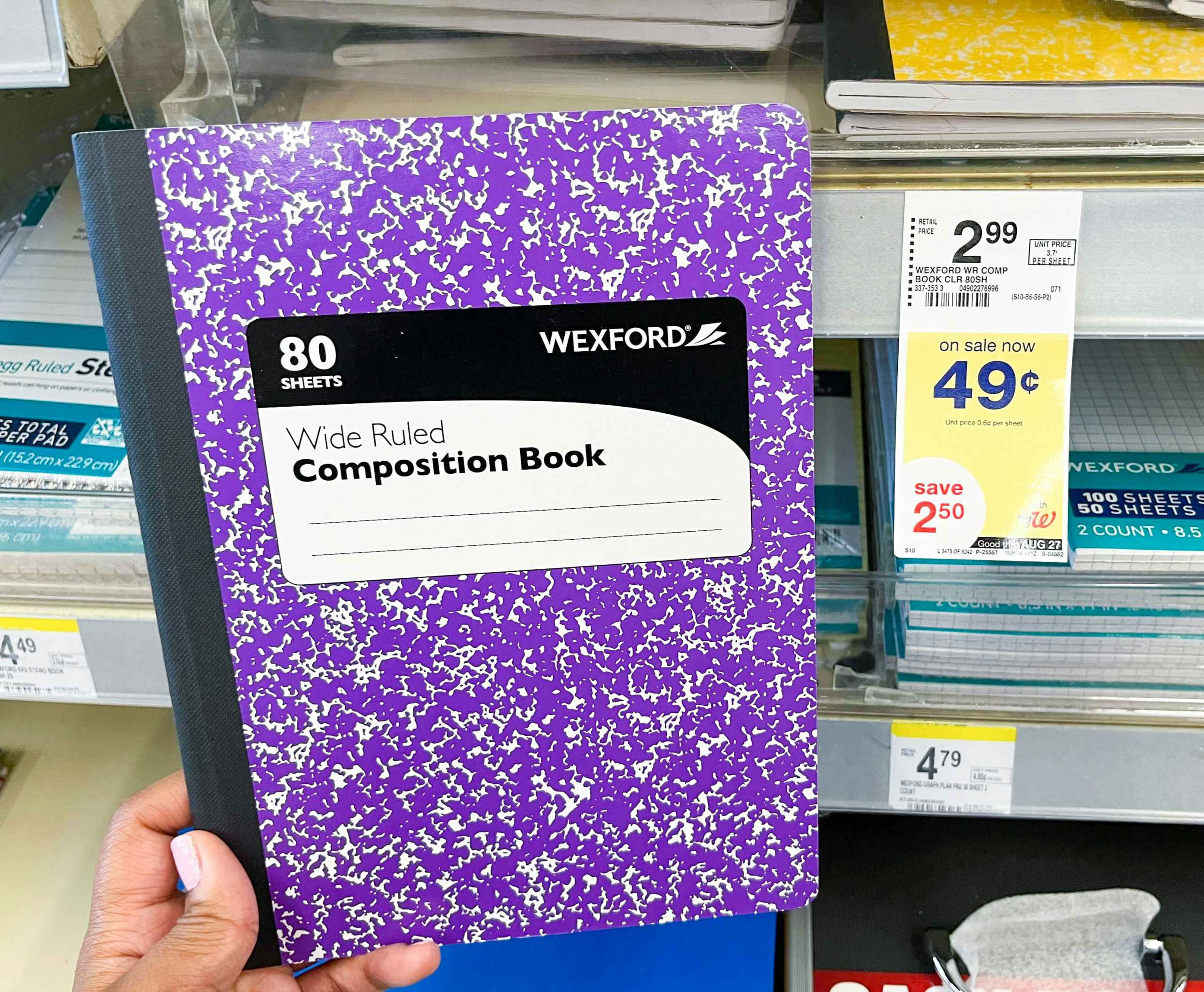 Hand holding Wexford Wide Ruled Composition Book next to sales tag