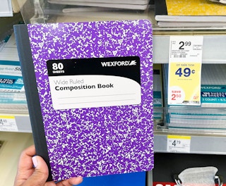 Hand holding Wexford Wide Ruled Composition Book next to sales tag