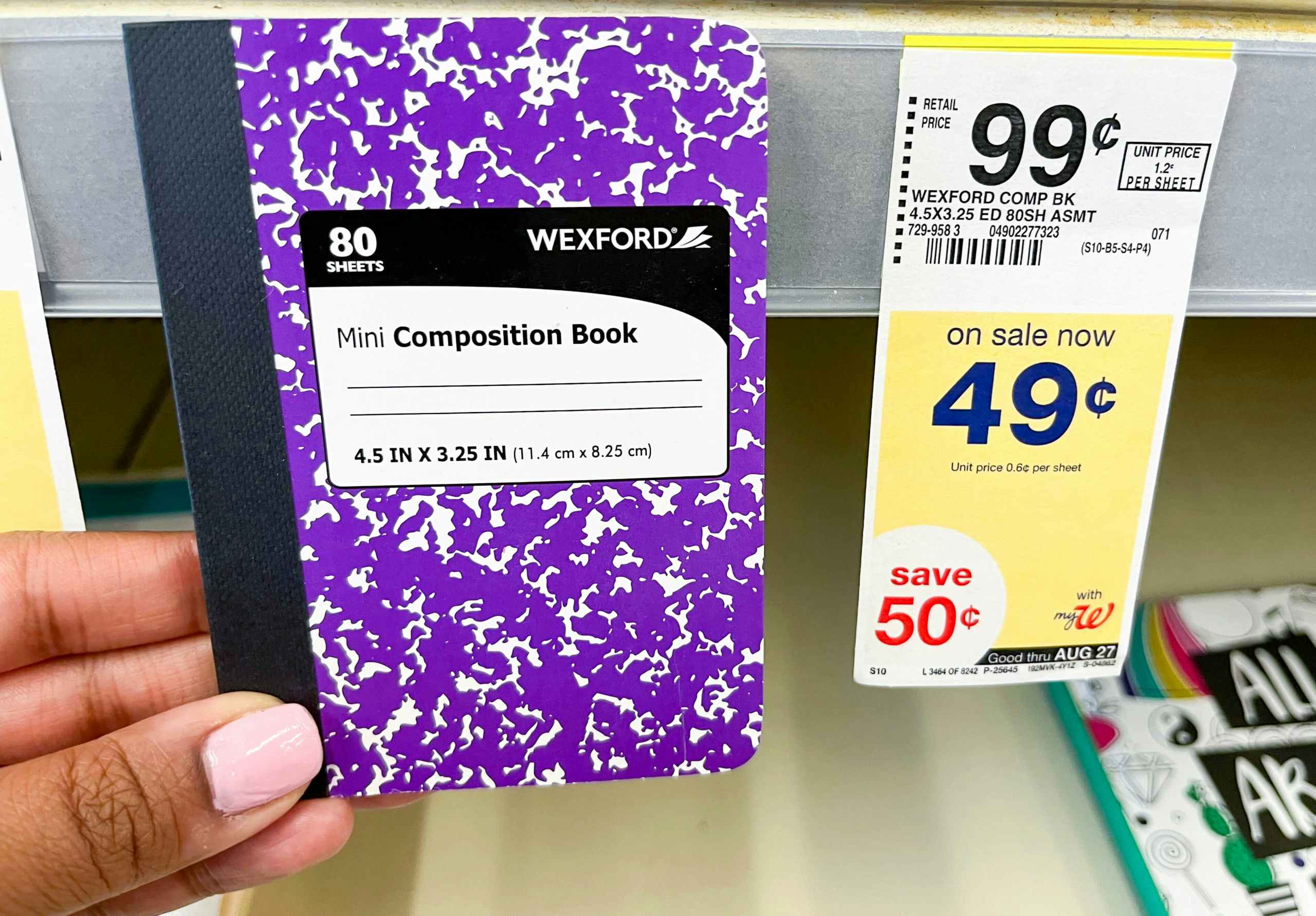 Hand holding Wexford mini composition book next to sales tag