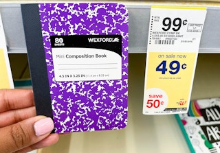 Hand holding Wexford mini composition book next to sales tag