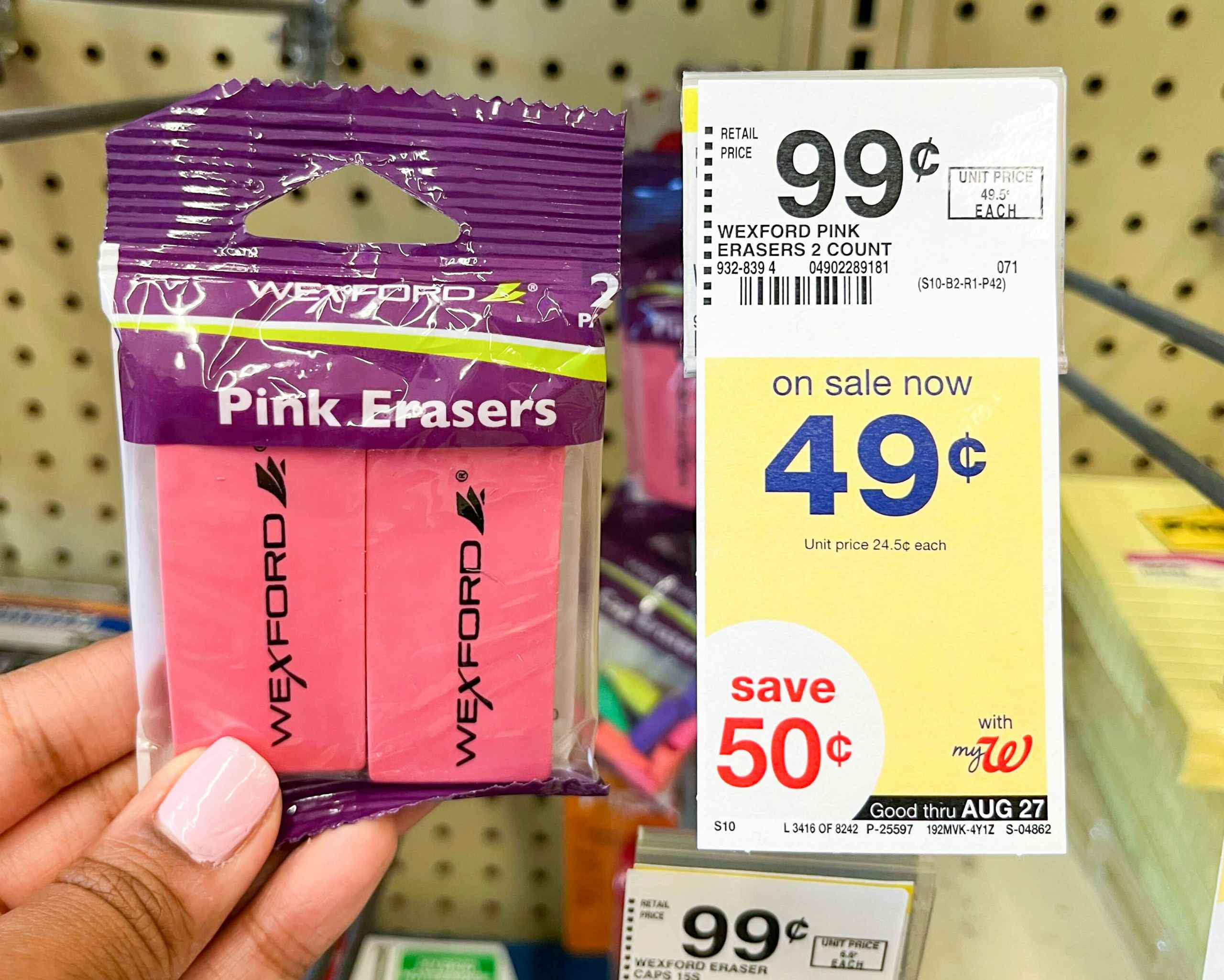 Hand holding Wexford pink erasers next to sales tag