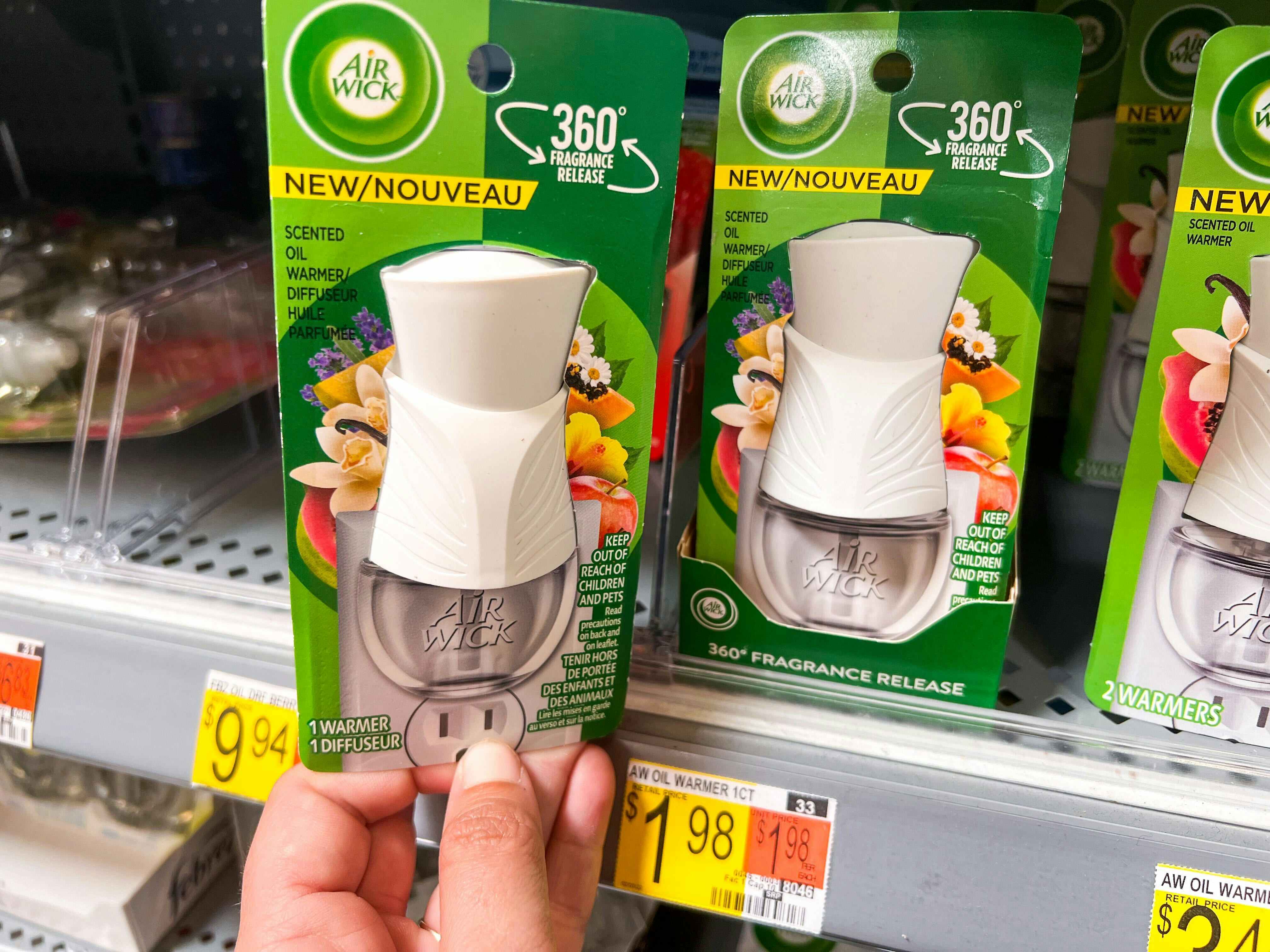 Air Wick Plug In Scented Oil Warmer held in front of shelf at Walmart. Price tag states that the price is $1.98.