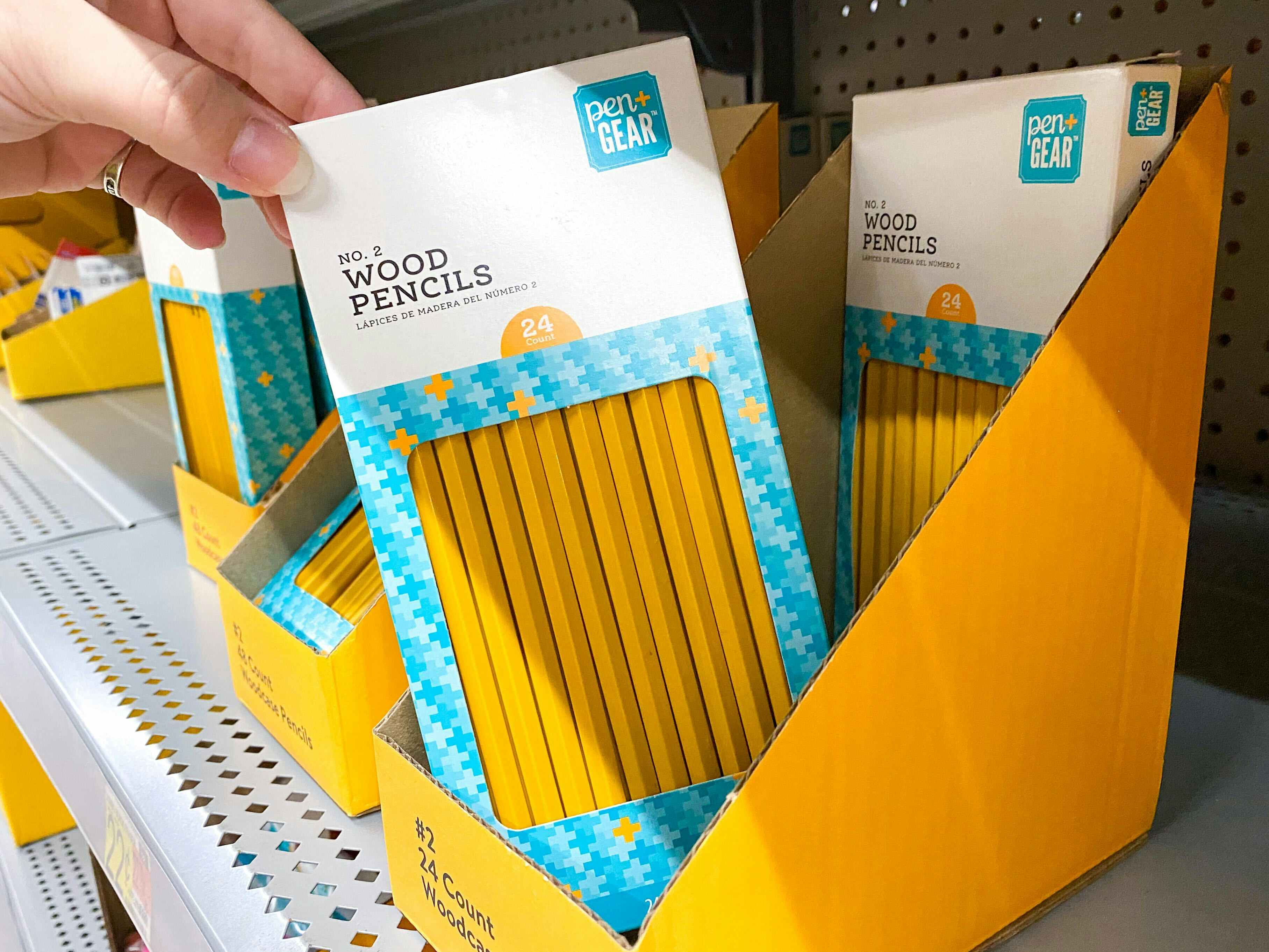 A person's hand taking a box of Pen+Gear pencils from a shelf at Walmart.