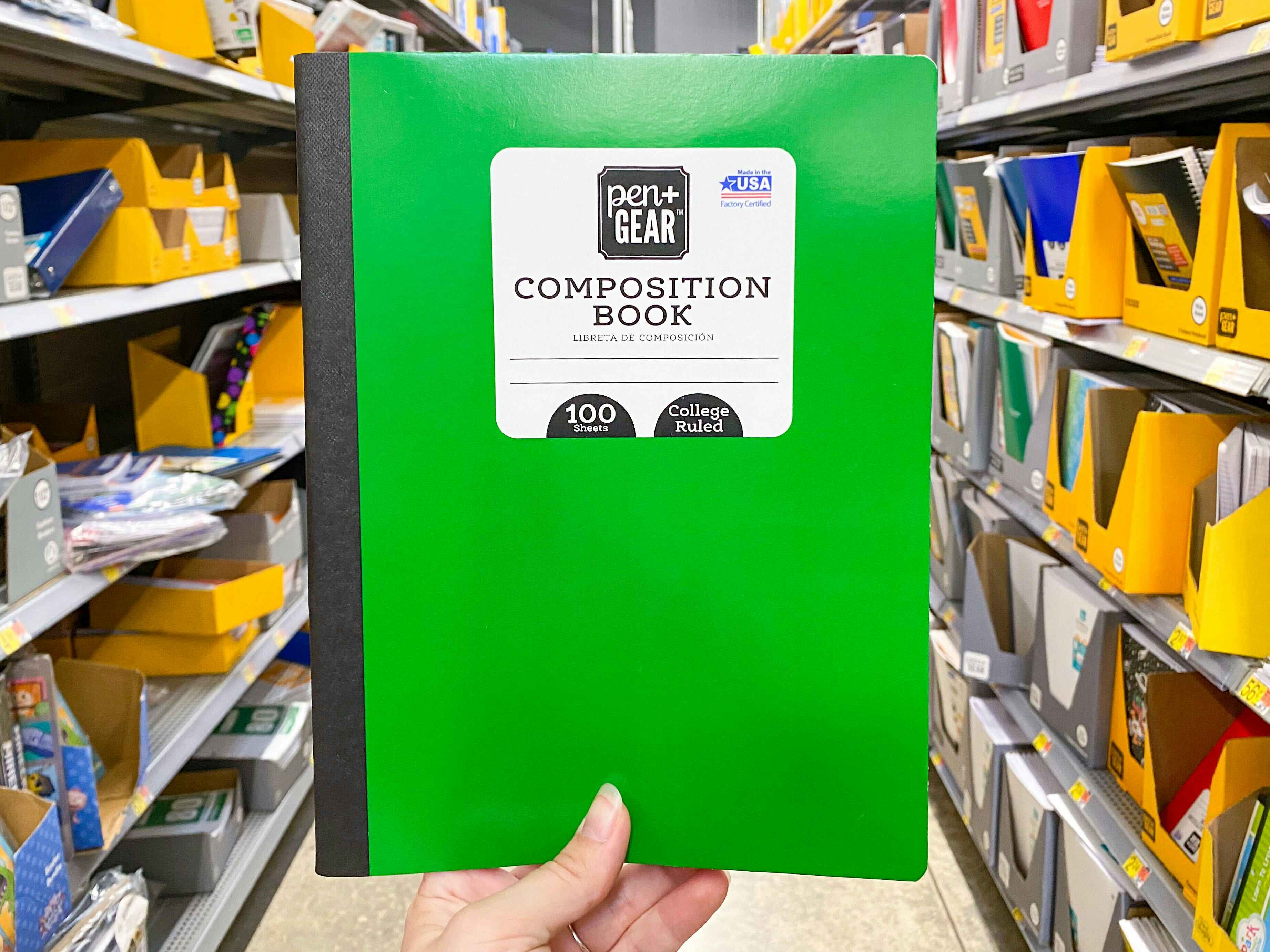 hand holding pen gear composition book at walmart
