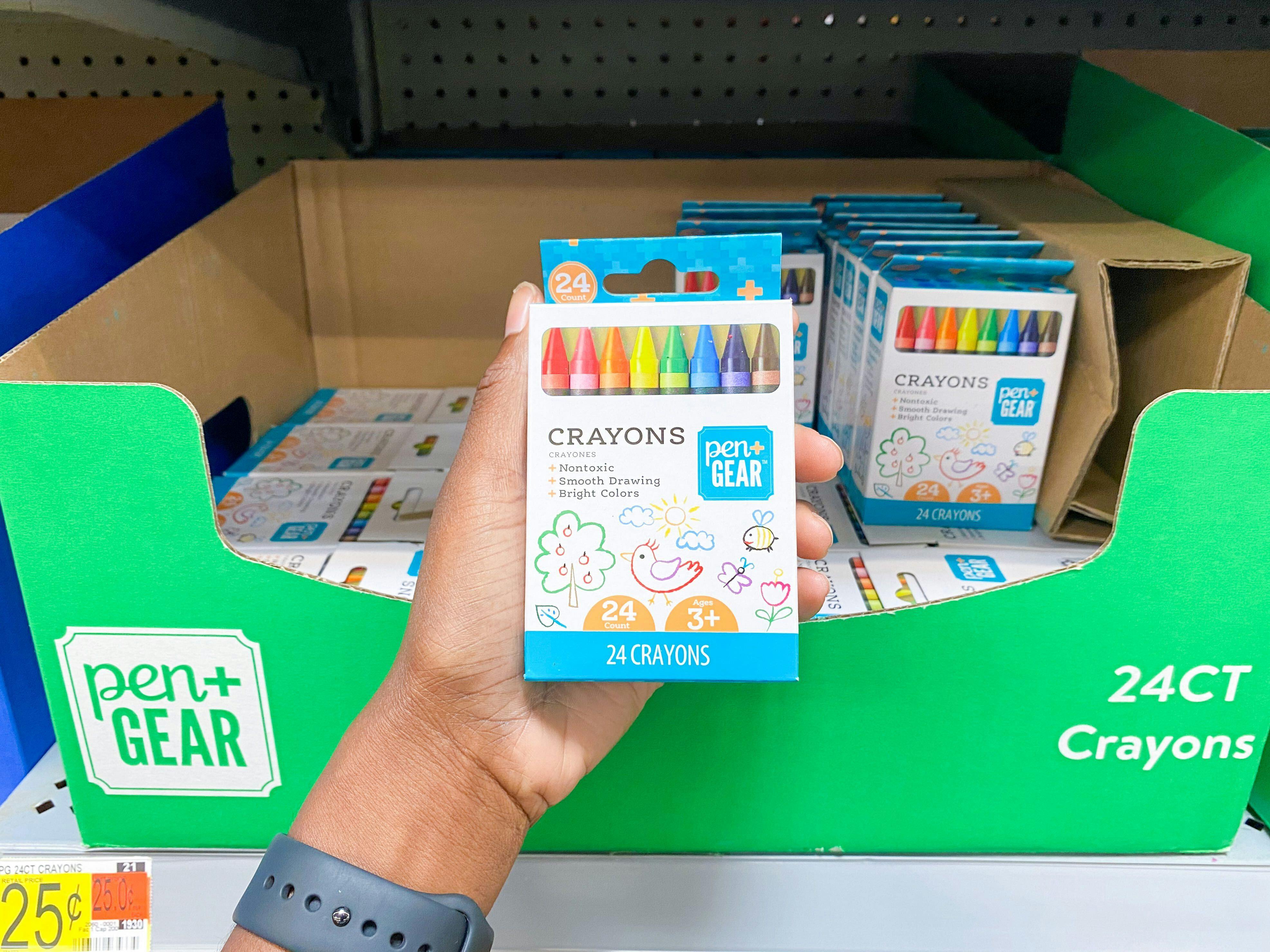 Pen + Gear Crayons held in front of shelf at Walmart