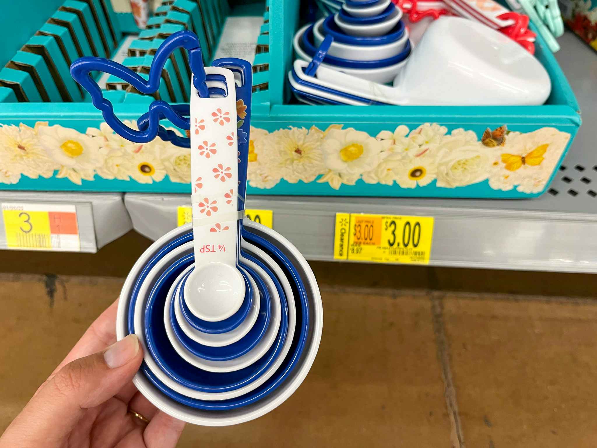 hand holding pioneer woman ditsy measuring cups at walmart