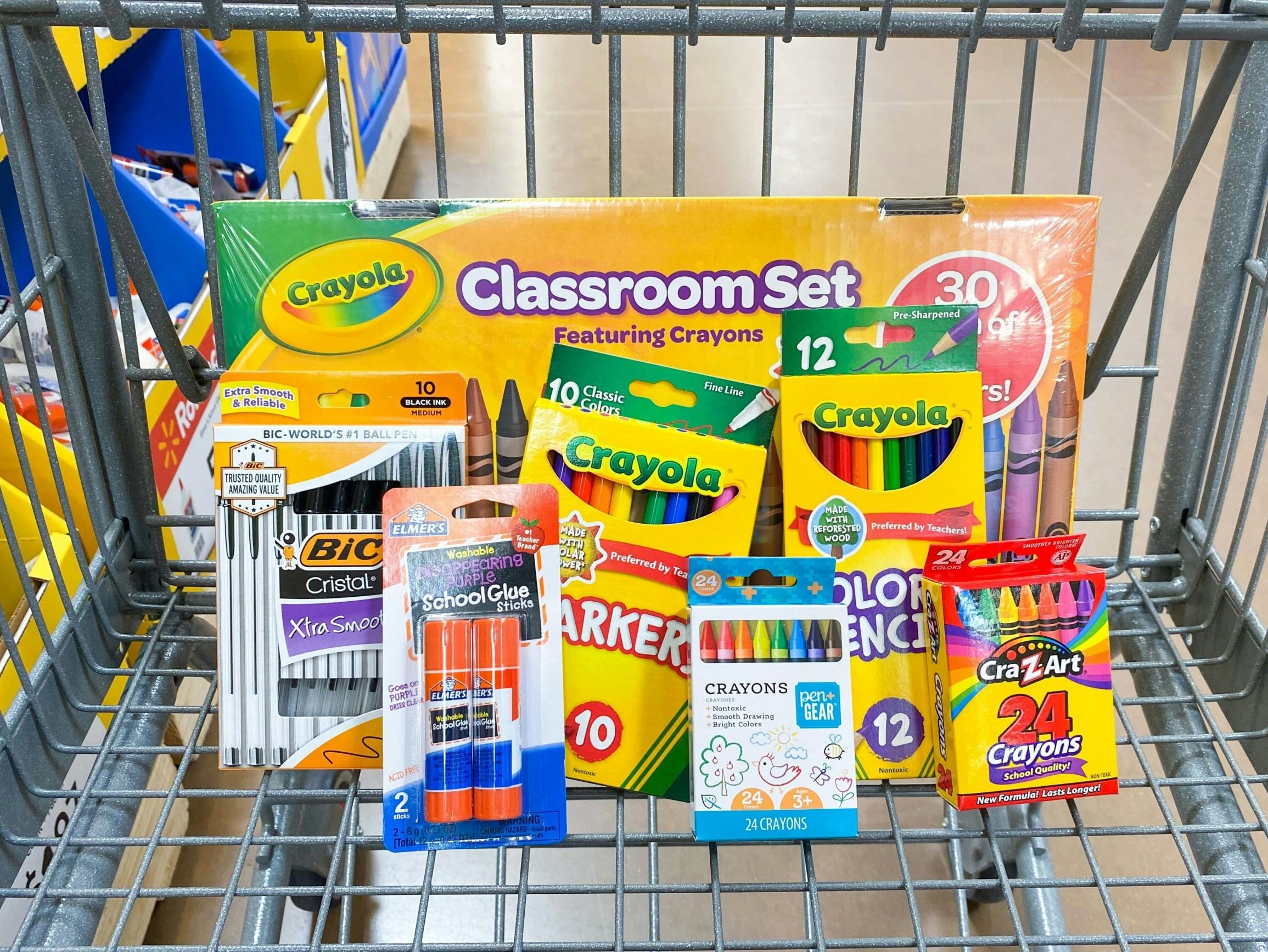 Crayola, BIC, CraZArt, Pen+Gear, and Elmer's school supplies in a Walmart shopping cart.